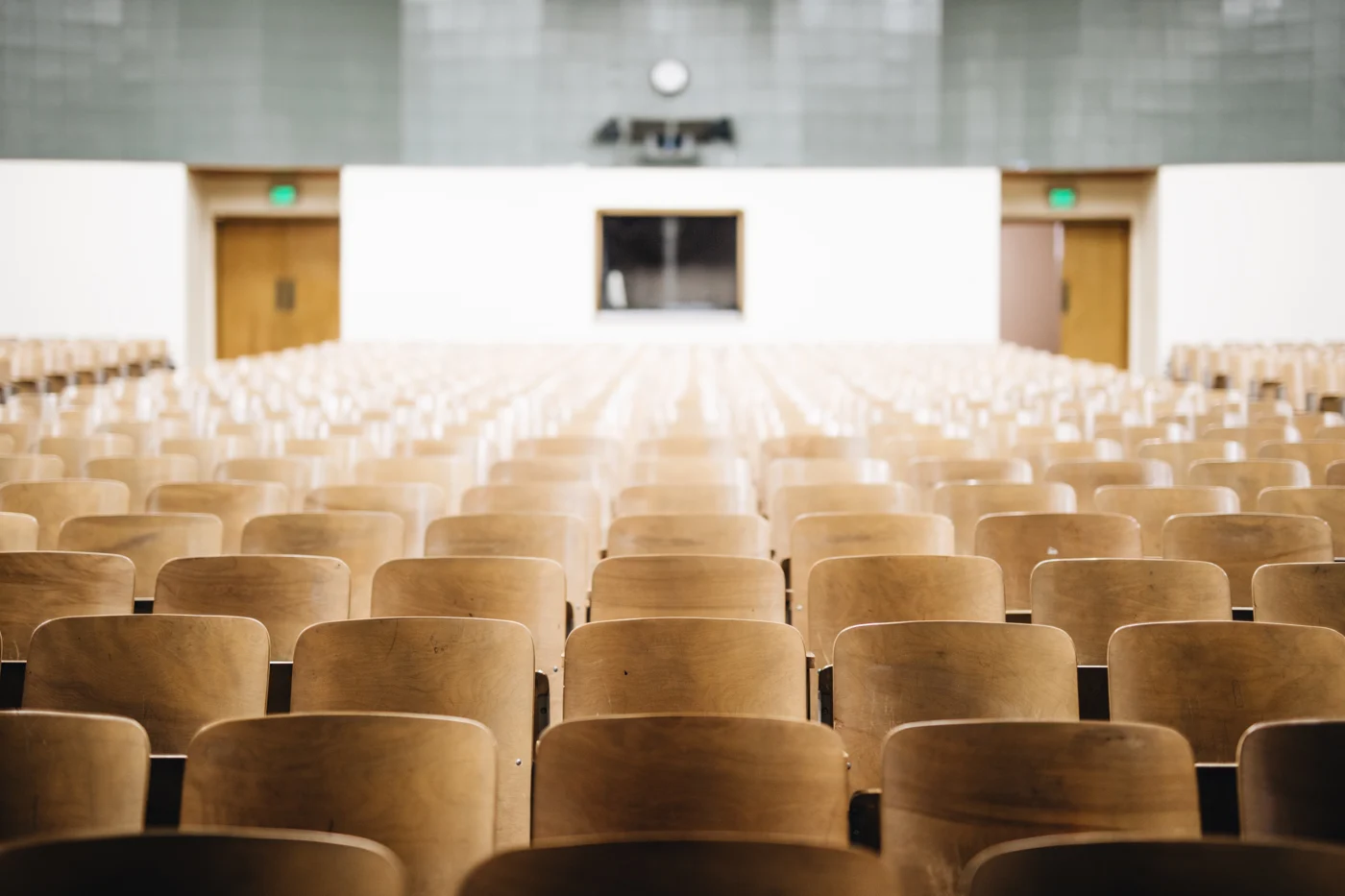 A lecture hall with tiered wooden seating